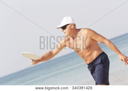 Adult Male Playing Matkot On The Beach