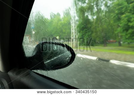 Driving Car In The Rain On Wet Road. Rainy Weather Through The Car Window. Rain Through Wind-screen 