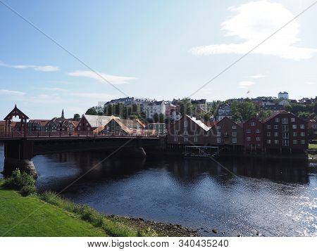 Wooden Town Bridge And Traditional Buildings At Nidelva River In European Nidaros City At Trondelag 