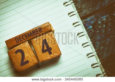 December 24th. Day 24 Of Month, Handmade Wood Cube With Date Month And Day Placed On A Lined Noteboo