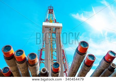 Oil And Gas Drilling Rig Onshore Dessert With Dramatic Cloudscape. Oil Drilling Rig Operation On The