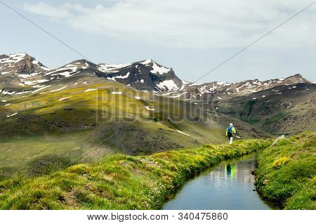 A Man Hiking In The High Mountains