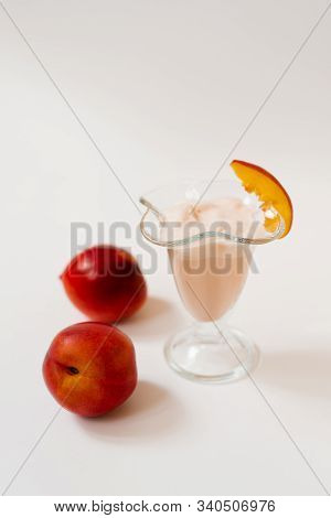Yogurt With Nectarines In A Glass, Next To Fresh Organic Nectarines. The Concept Of Healthy And Deli