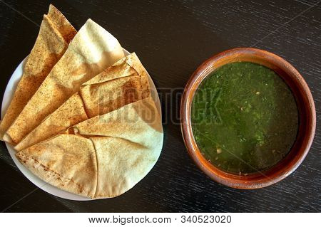 Famous Traditional Arabic Cuisine. Molokhia Soup With Pita Bread On Dark Wooden Background. Flat Lay