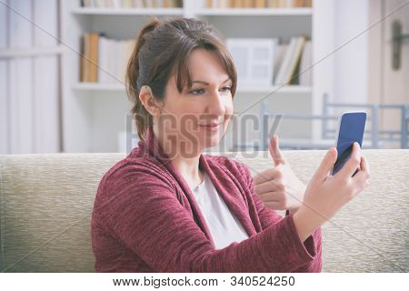Deaf woman wearing hearing aid and using smartphone