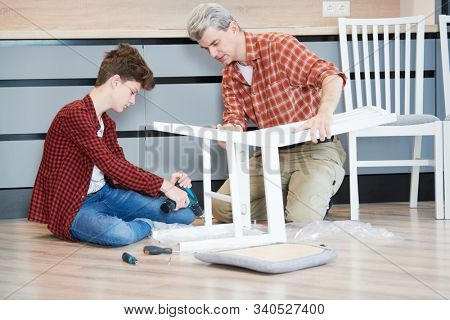 father and son work together. kitchen chair assembling