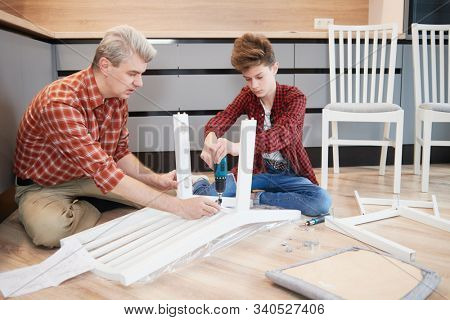 father and son work together. kitchen chair assembling