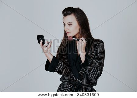 Girl In Coat Makes Brush Makeup Looks In The Mirror
