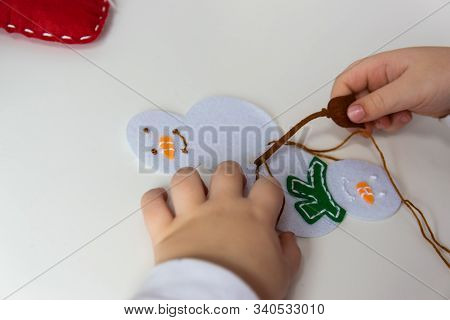 The Hand Of The Child Make Snowman For Christmas Greeting Card. Hobby Concept. Handmade.