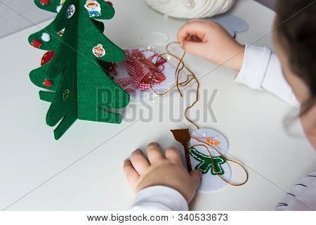 The Hand Of The Child Make Snowman And Christmas Tree For Christmas Greeting Card. Xmas Toys Decorat