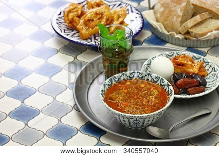moroccan ramadan iftar meal, harira soup, chebakia, dates, mint tea and khubz