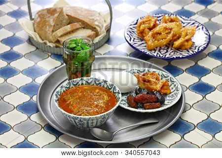 moroccan ramadan iftar meal, harira soup, chebakia, dates, mint tea and khubz