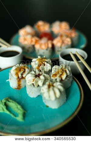 Sushi Rolls In Blue Plate, Chopsticks, Soy Sauce, Ginger And Wasabi