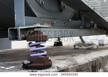 Old Rusty Vibration Damper In Use Supporting The Electric Motor Over The Concrete Foundation