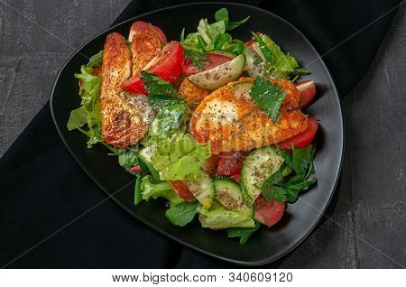 Salad With Vegetables And Fried Halumi Cheese With Spices. On A Black Plate. View From Above. Dark B