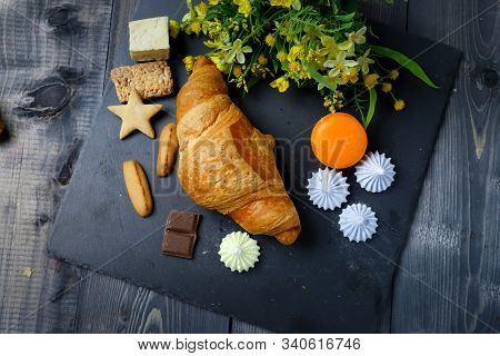 In The Center Of Composition French Croissant On Graphite Colors Of Flat Stone Meringue Tiles There