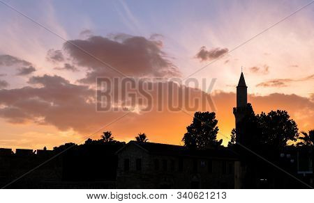 Silhouette Of Buyuk Cami Mosque And Palm Trees Against Colorful Sky At Sunset.