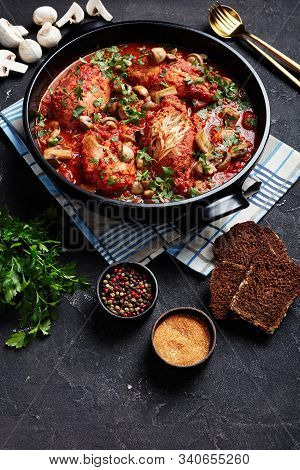 Chicken Breasts Cacciatore With Tomatoes, Bell Peppers, Carrots And Sliced Mushrooms In A Black Cera