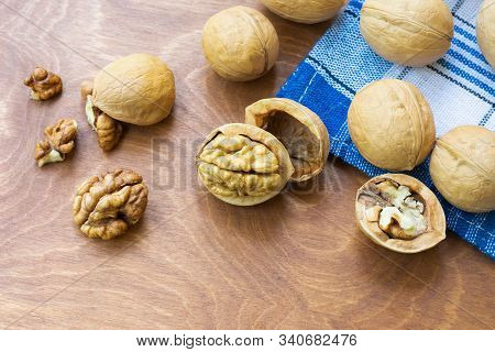 Whole Walnuts And Walnut Kernel Halves Without Shell On A Dark Wooden Table And Checkered Towel, Clo