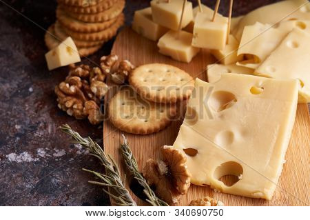 Pieces Of Cheese, Nuts, Raisins, Snacks For Wine On A Wooden Background. Appetitive