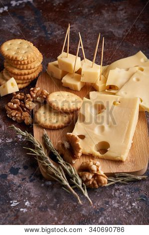 Pieces Of Cheese, Nuts, Raisins, Snacks For Wine On A Wooden Background. Appetitive