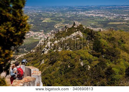Sintra, Portugal - May, 2018: Couple Of Tourists Visiting The Pena Palace A Romanticist Castle Locat