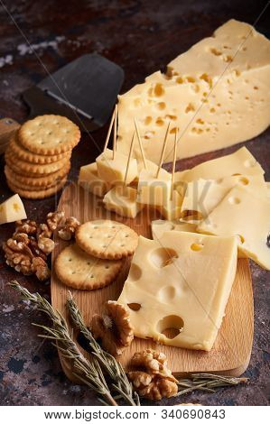 Pieces Of Cheese, Nuts, Raisins, Snacks For Wine On A Wooden Background. Appetitive Copy Space