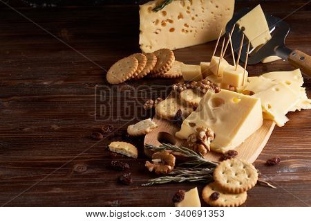 Pieces Of Cheese, Nuts, Raisins, Snacks For Wine On A Wooden Background. Appetitive