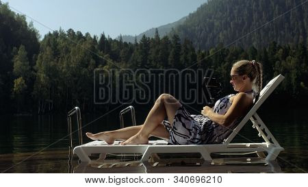 Woman Shooting On Handheld Film Gimbal Stabilization For Smartphone. Girl Lie Sunbed On Pier Make Se