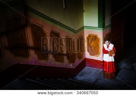 altar boy collecting money in a box for catholic church. conceptual image