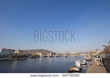 Panorama Of Prague, Czech Republic, Seen From The Vltava River, With A Focus On Palackevo Most Bridg