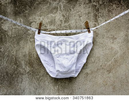 Underware And Tape Measure On Concrete Wall Background.