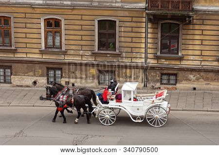 Horse Carriage On The Street Of The Old Town In Krakow, Poland. Two Horses In Beautiful Old-fashione