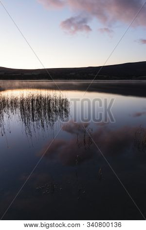 Stunning Sunrise Autumn Fall Landscape Image Of Ullswater In Lake District With Golden Sunlight