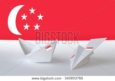Singapore Flag Depicted On Paper Origami Airplane And Boat. Handmade Arts Concept