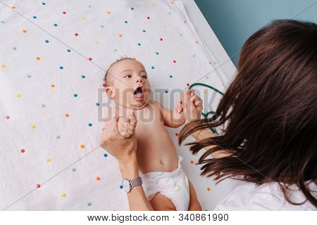 Pediatrician Doctor Checks The Babys Grasping Reflexes