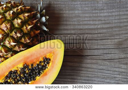 Ripe Organic Papaya And Pineapple Tropical Fruit Cut In Half On Old Wooden Table.healthy Eating,diet