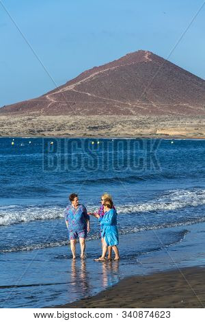 El Medano, Spain - July 9 2019: Senior Local Women Walking On Playa El Medano Beach During Sunrisee