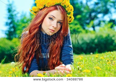 Romantisk ung kvinde i en tudorroser af blomster udendørs.