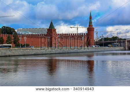 Daytime View Of The Red Kremlin Wall And Tower With The Traffic On Kremlevskaya Embankment By The Mo