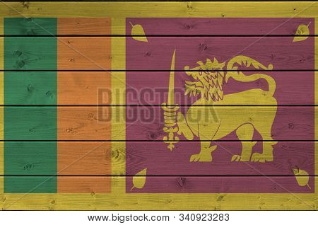 Sri Lanka Flag Depicted In Bright Paint Colors On Old Wooden Wall. Textured Banner On Rough Backgrou