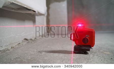 Laser Level At Work. Laser Level And Concrete Walls And Floor. Apartment Renovation.