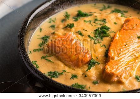 Salmon Creame Soupe In Bowl With Spoon On Wooden Table