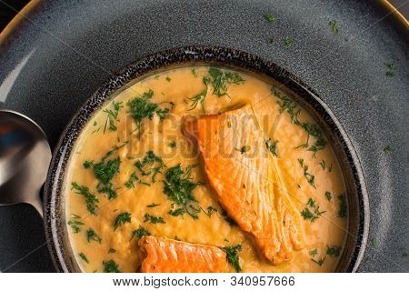 Salmon Creame Soupe In Bowl With Spoon On Wooden Table