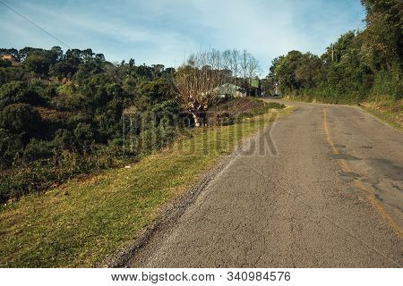 Bucolic Rural Landscape With Asphalt Road Going Through The Hill And Woods In A Cloudy Day Near Bent