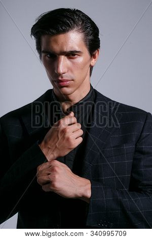 Frontal Portrait Man In Black Suit, Arranged His Buttons On Jacket, Poses With Attitudine, Over Whit