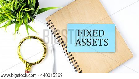 Notebook With Tools And Notes With Text On Blue Sticker Fixed Assets