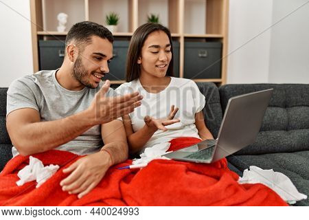 Young latin ill couple having medical teleconsultation using laptop at home.