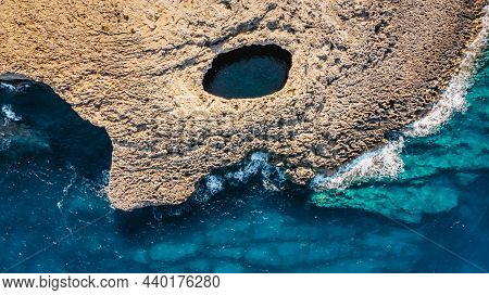 Aerial View Of Ahrax Fallen Cave,coral Lagoon,malta.hole In The Middle Of Rocks With Crystal Clear W