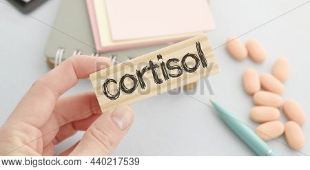 Doctor Holds Wooden Block In His Hands With Text Cortisol